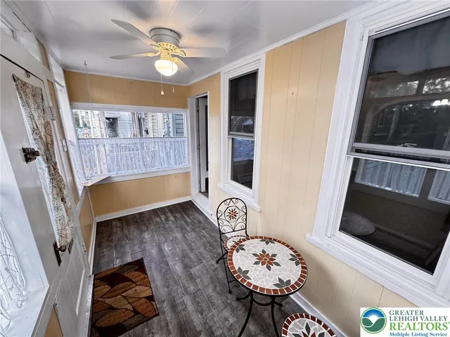an empty room with ceiling fan and window