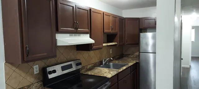 a kitchen with a refrigerator sink and stove