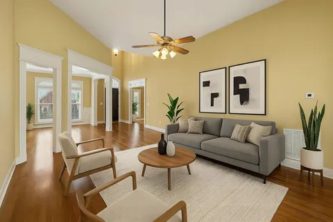 a view of an empty room with wooden floor fireplace and a window