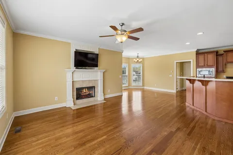 a view of a room with a ceiling fan and wooden floor