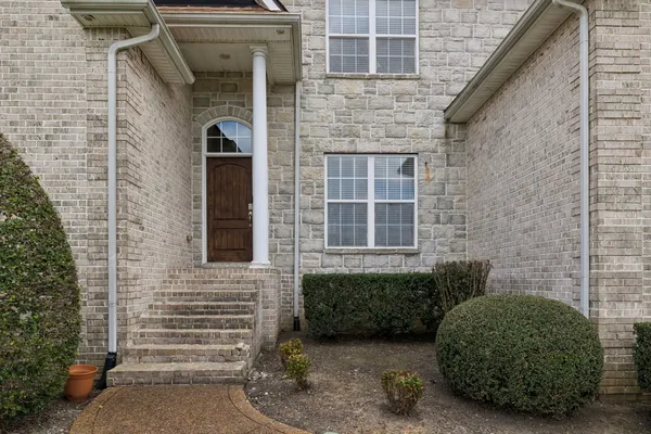 a kitchen with stainless steel appliances granite countertop a refrigerator a stove and a sink with wooden floor
