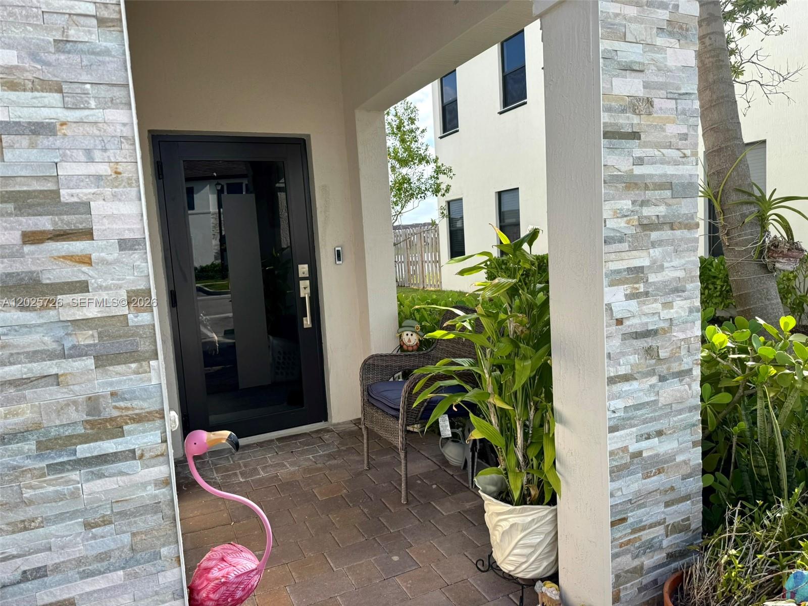 10020 Southwest 228th Terrace Miami, FL 33190 - Photo 21 of 22 a potted plant sitting in front of a door