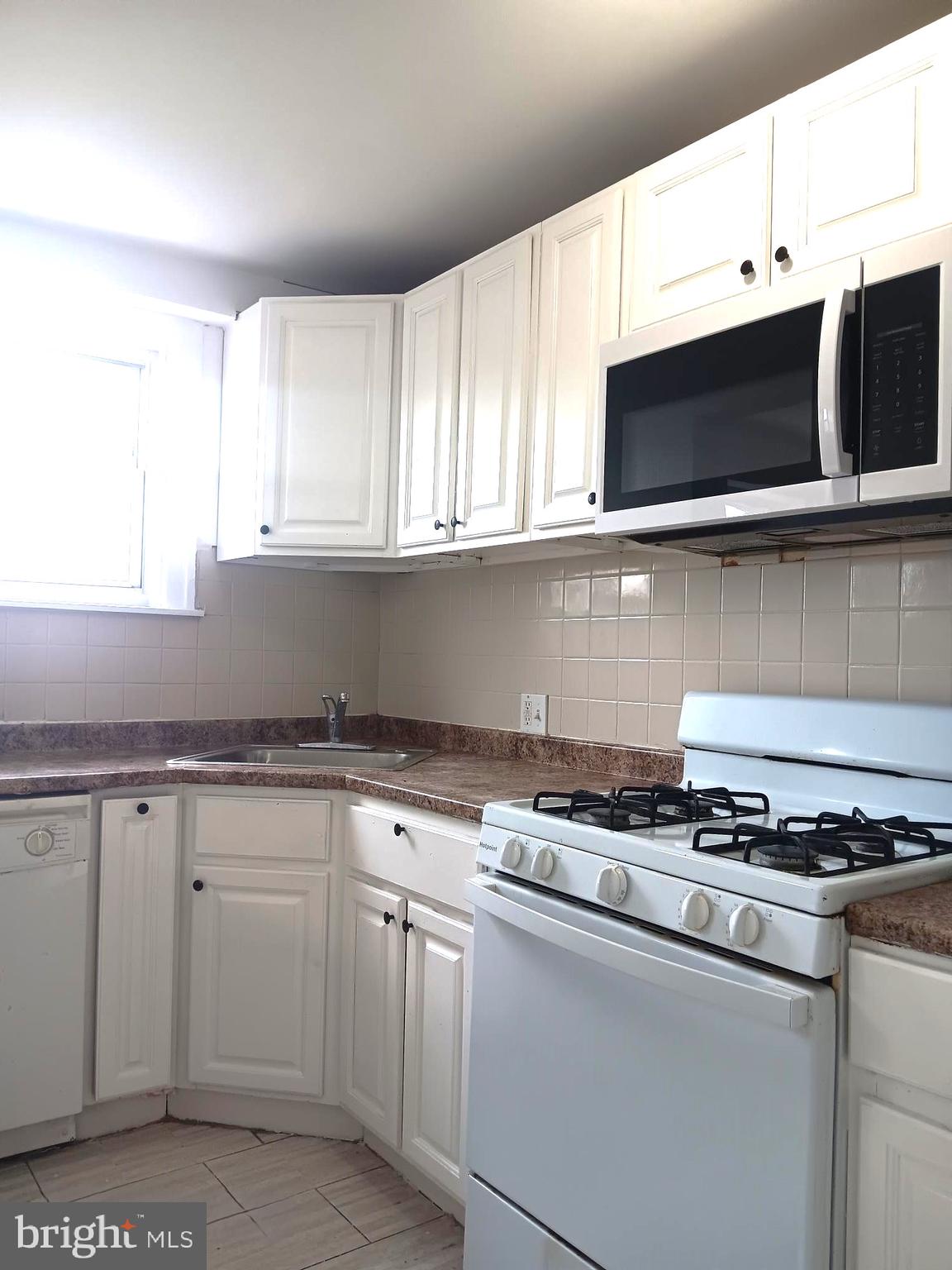 1815 Penfield Street Philadelphia, PA 19126 - Photo 4 of 11 a kitchen with stainless steel appliances granite countertop a sink and a stove