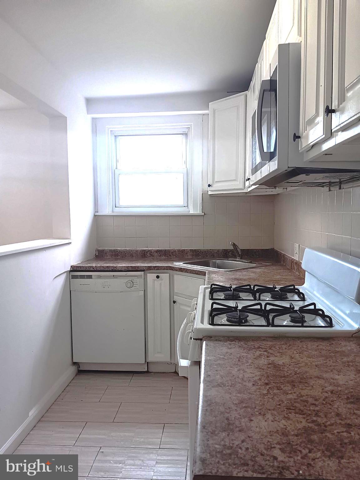 1815 Penfield Street Philadelphia, PA 19126 - Photo 5 of 11 a kitchen with granite countertop a stove and a microwave