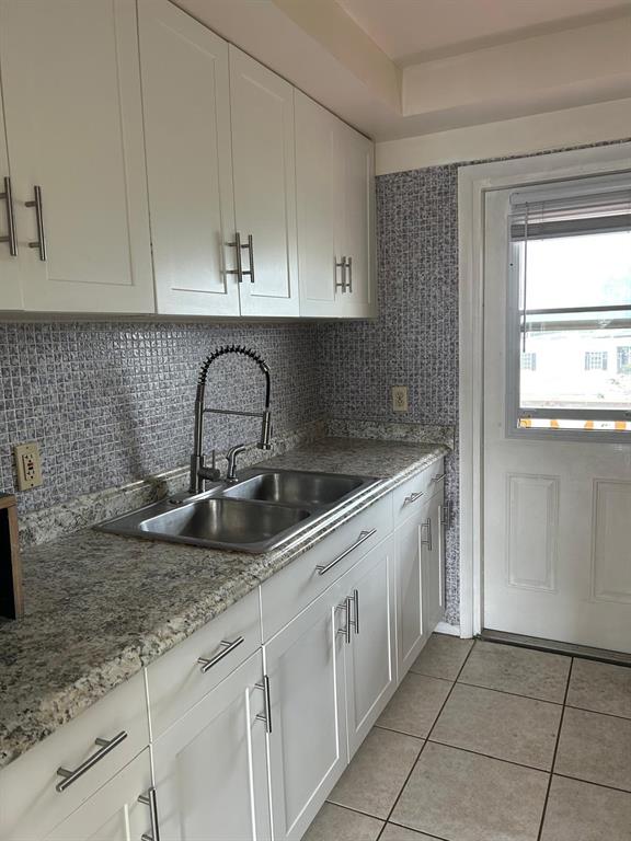 1050 East Sample Road, Unit 209 Pompano Beach, FL 33064 - Photo 3 of 6 a kitchen with granite countertop a sink and a white cabinets