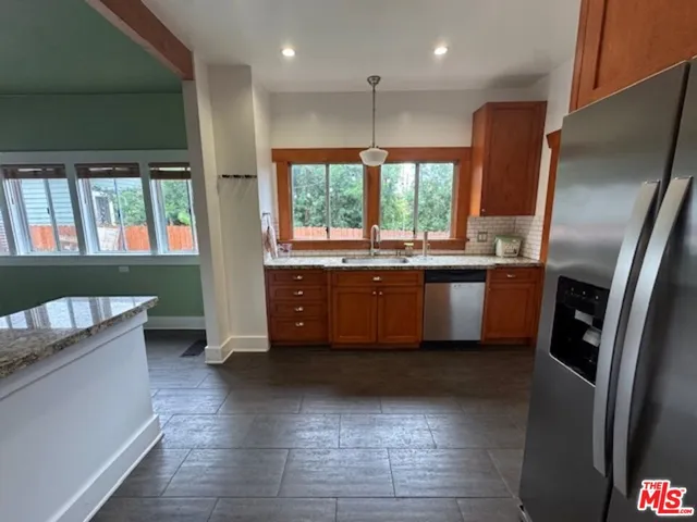 a kitchen with stainless steel appliances granite countertop a refrigerator a sink a stove a microwave and island