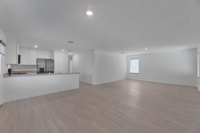 a view of kitchen with kitchen island white cabinets and refrigerator