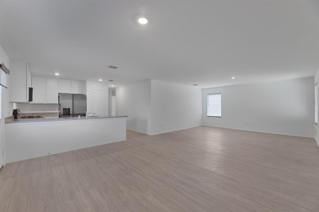 a view of kitchen with kitchen island white cabinets and refrigerator
