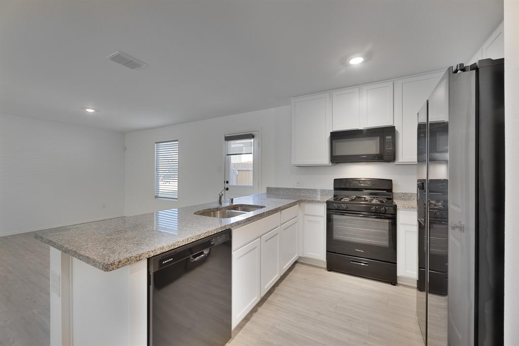 9752 Platteview Road Fort Worth, TX 76179 - Photo 13 of 25 a kitchen with stainless steel appliances a sink stove and refrigerator