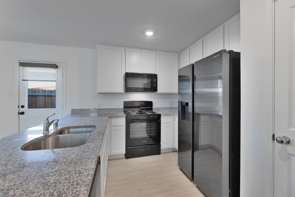 9752 Platteview Road Fort Worth, TX 76179 - Photo 2 of 25 a kitchen with stainless steel appliances granite countertop a refrigerator and a sink
