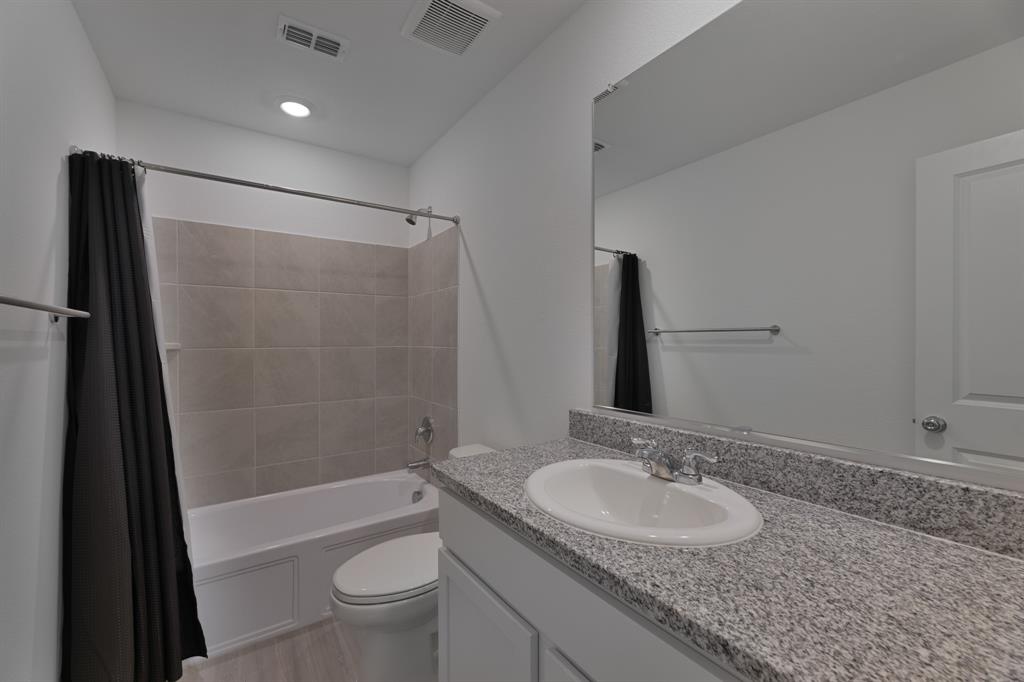 9752 Platteview Road Fort Worth, TX 76179 - Photo 20 of 25 a bathroom with a granite countertop sink toilet and shower a mirror