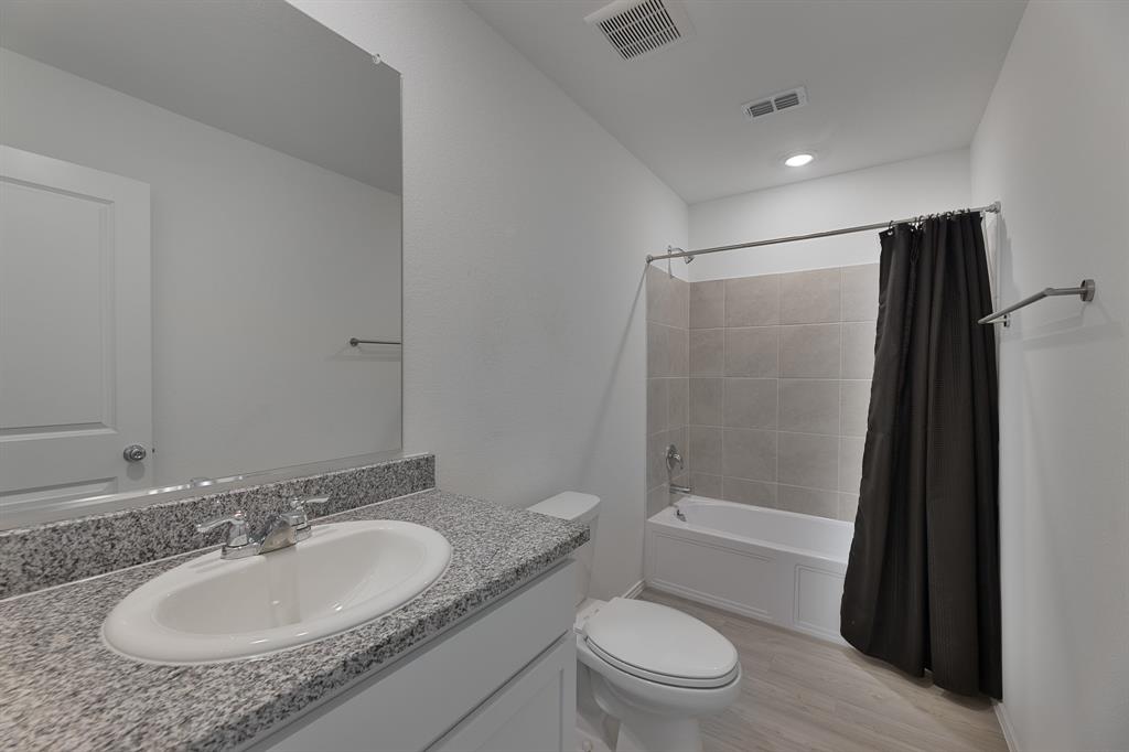 9752 Platteview Road Fort Worth, TX 76179 - Photo 23 of 25 a bathroom with a granite countertop sink toilet and shower