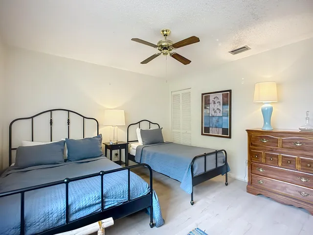 a bedroom with a bed a dresser and with closet