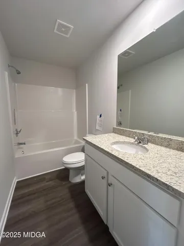 a bathroom with a granite countertop toilet a sink and bathtub