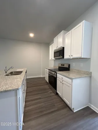a kitchen with granite countertop a sink and a stove top oven