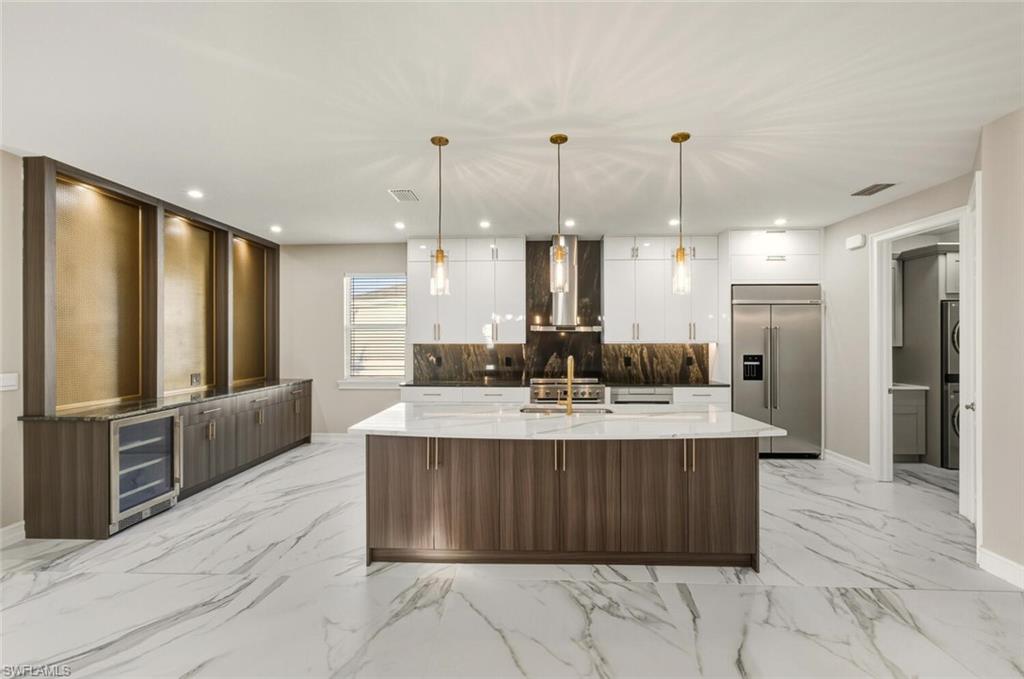 28049 Captiva Shell Loop Bonita Springs, FL 34135 - Photo 9 of 50 a large kitchen with kitchen island a island a counter top space a sink stainless steel appliances and cabinets