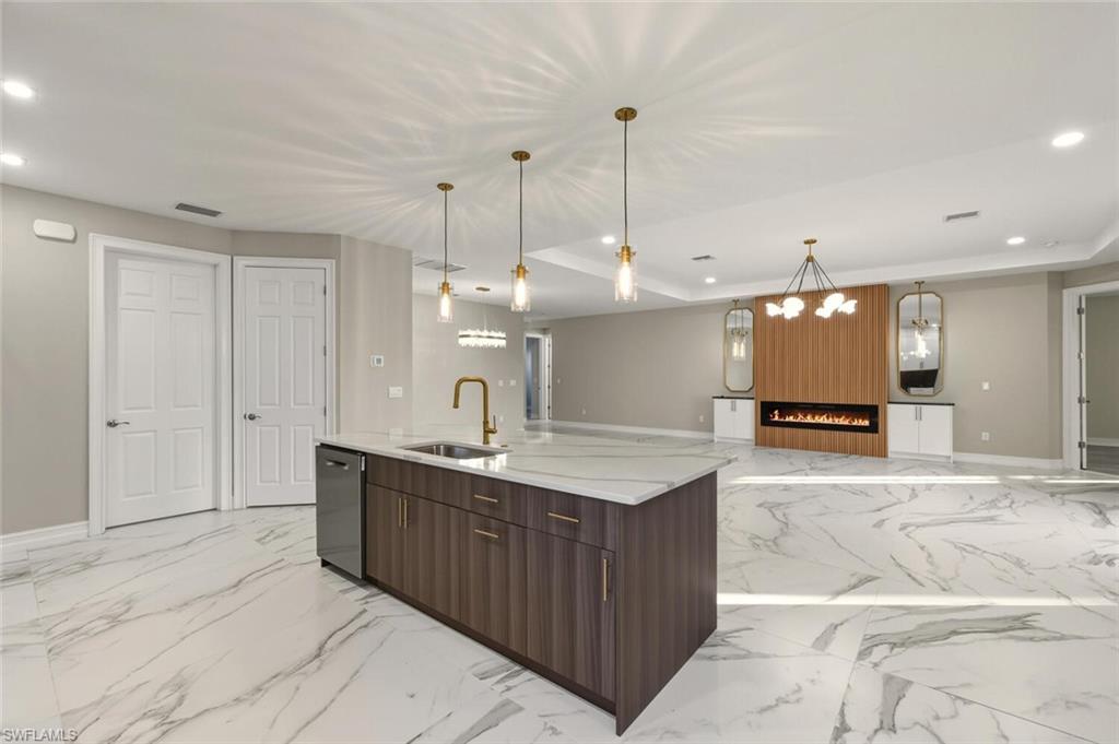 28049 Captiva Shell Loop Bonita Springs, FL 34135 - Photo 49 of 50 a large kitchen with kitchen island a sink counter space and a view of living room