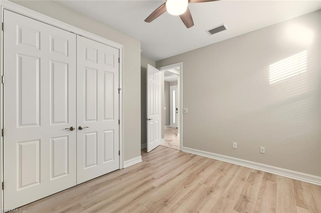 28049 Captiva Shell Loop Bonita Springs, FL 34135 - Photo 27 of 50 an empty room with wooden floor ceiling fan and windows