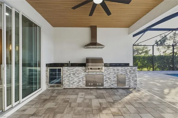 an empty room with wooden floor ceiling fan and windows