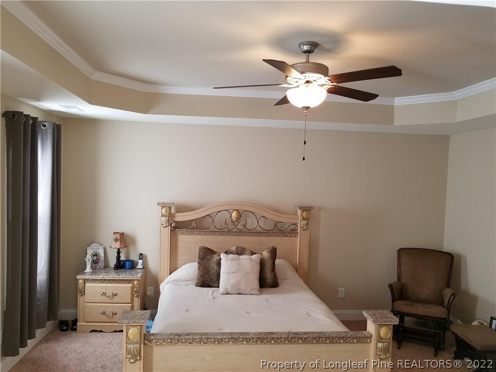 3720 Thrower Road Hope Mills, NC 28348 - Photo 14 of 26 a bedroom with a bed and a chandelier
