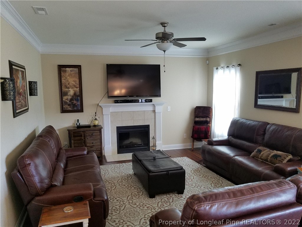 3720 Thrower Road Hope Mills, NC 28348 - Photo 8 of 26 a living room with furniture a flat screen tv and a fireplace
