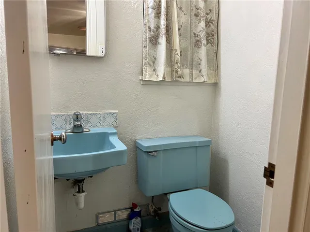 a bathroom with a sink a toilet and a mirror