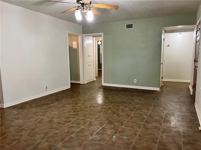 an empty room with closet and chandelier fan