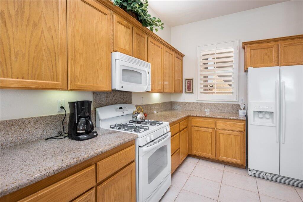 49562 Wayne Street Indio, CA 92201 - Photo 11 of 52 a kitchen with stainless steel appliances granite countertop a sink a stove and a refrigerator