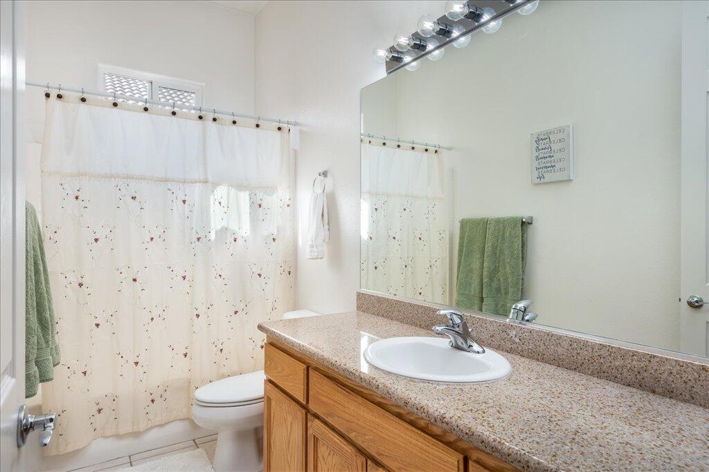 49562 Wayne Street Indio, CA 92201 - Photo 16 of 52 a bathroom with a granite countertop sink a toilet and a mirror