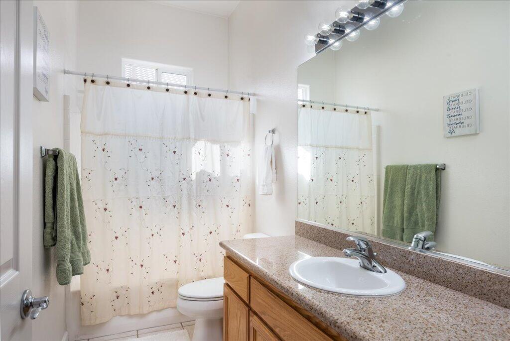 49562 Wayne Street Indio, CA 92201 - Photo 17 of 52 a bathroom with a granite countertop sink a toilet and a mirror