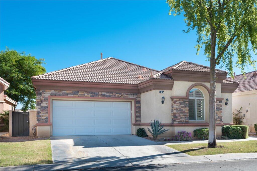 49562 Wayne Street Indio, CA 92201 - Photo 3 of 52 a front view of a house with garden