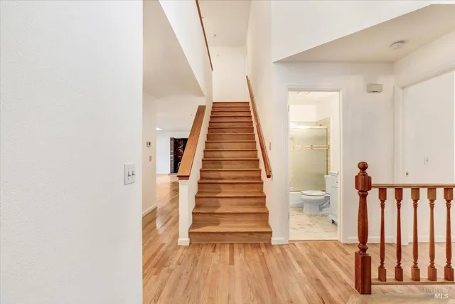 a view of a hallway with wooden floor and stairs