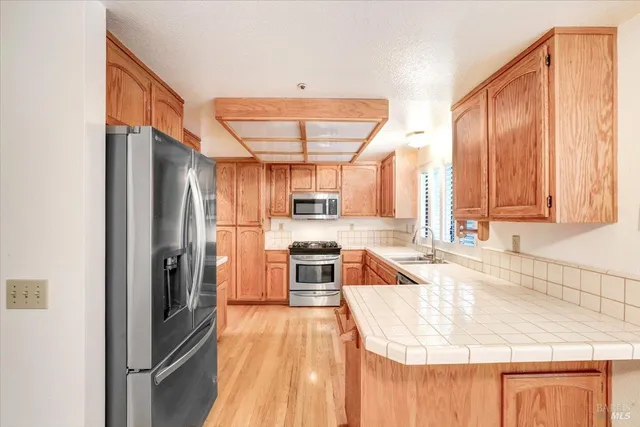 a kitchen with stainless steel appliances granite countertop a refrigerator a sink and a stove