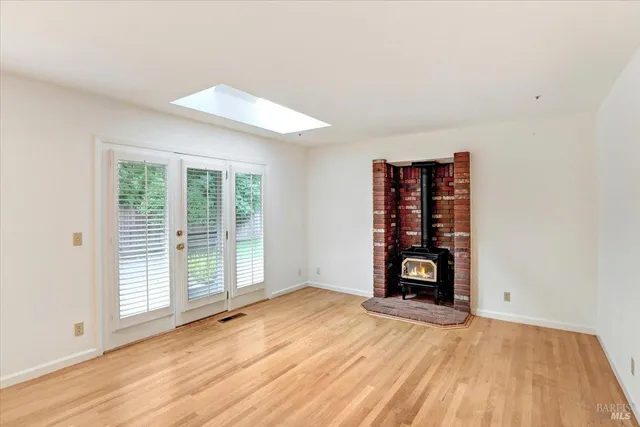 an empty room with window and wooden floor