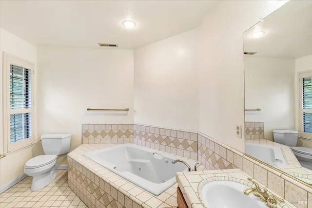a bathroom with a granite countertop sink and a bathtub