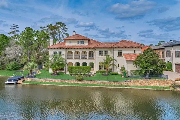 a front view of a house with a garden and a pond