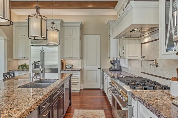 a kitchen with stainless steel appliances granite countertop a sink stove and refrigerator