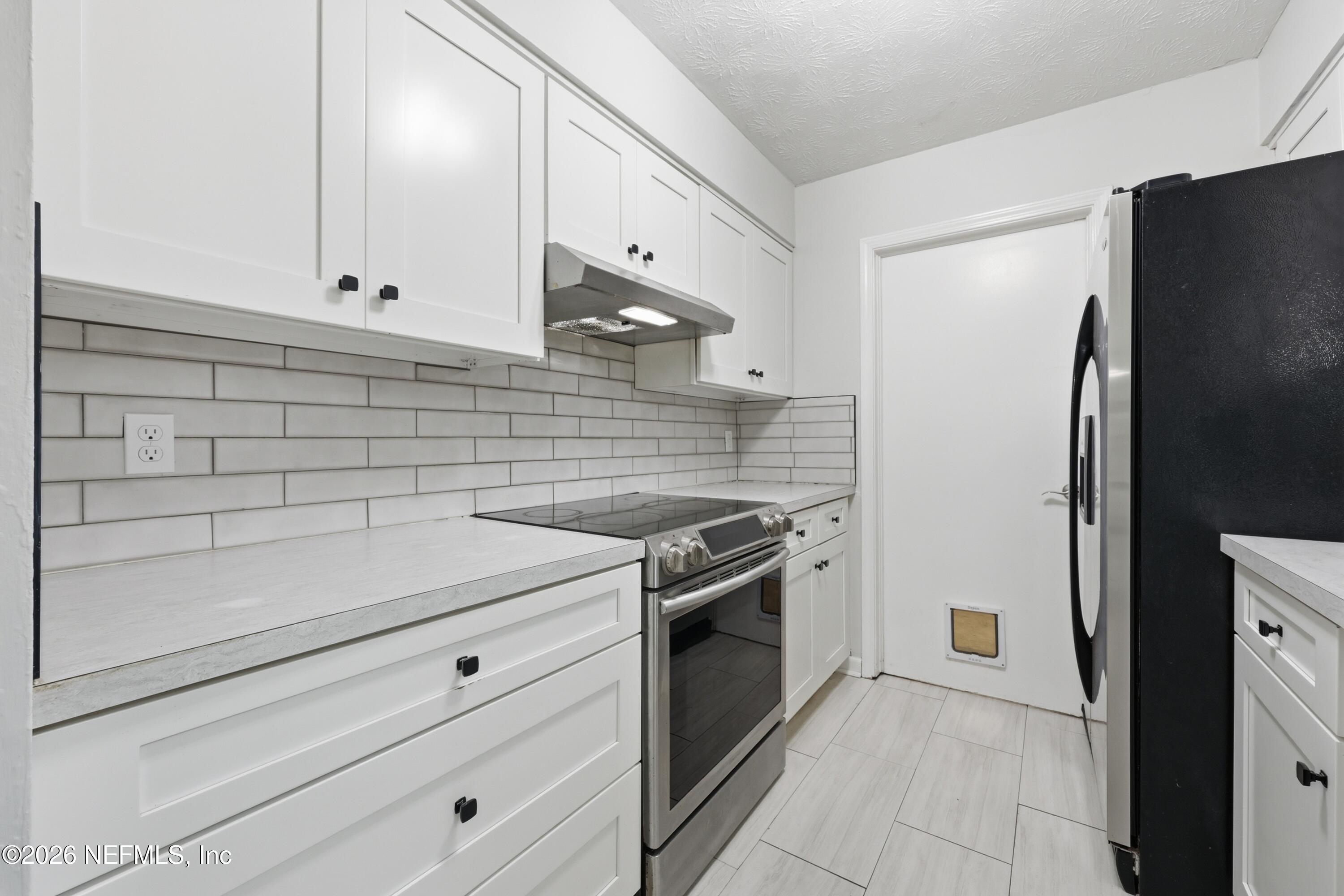 7 Cobia Street Ponte Vedra Beach, FL 32082 - Photo 7 of 20 a kitchen with stainless steel appliances wooden cabinets and a refrigerator