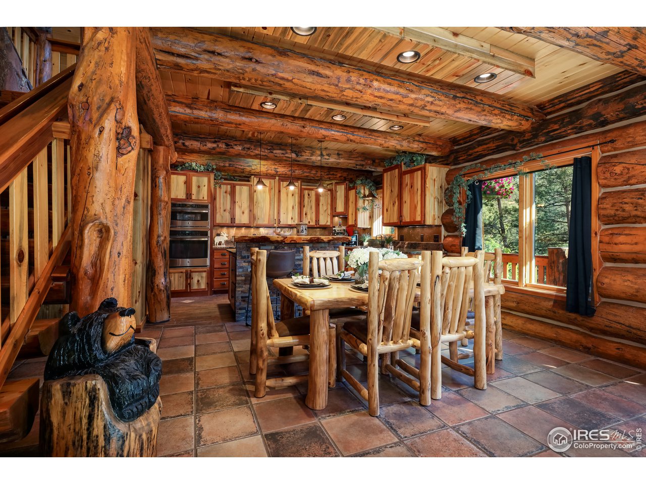 381 Wichita Road Lyons, CO 80540 - Photo 11 of 40 Dining area with rustic tile, dramatic wood beam and a cozy ambiance