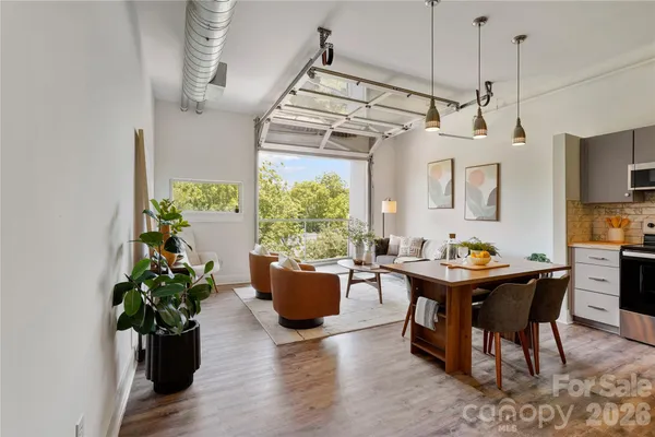 a view of a dining room and livingroom with furniture wooden floor a chandelier