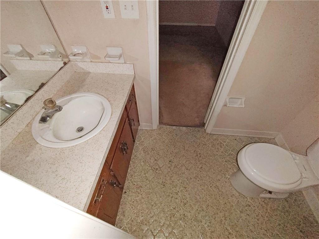 497 Highway 212 Covington, GA 30016 - Photo 11 of 14 a bathroom with a sink a toilet and a mirror