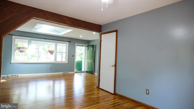 an empty room with windows and chandelier fan