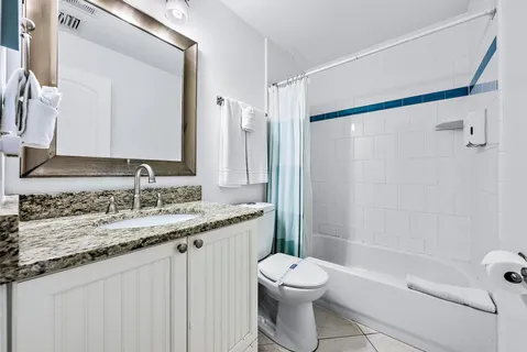 a bathroom with a granite countertop sink a toilet and shower
