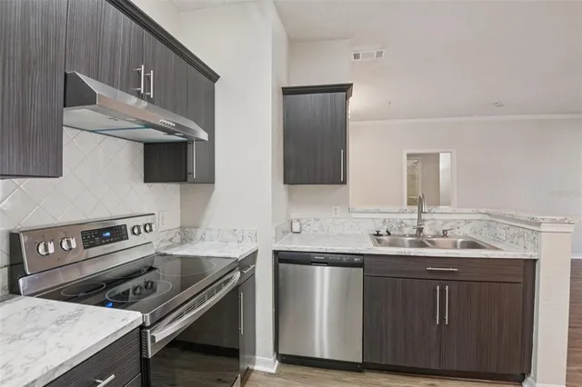 a kitchen with stainless steel appliances a sink stove and cabinets