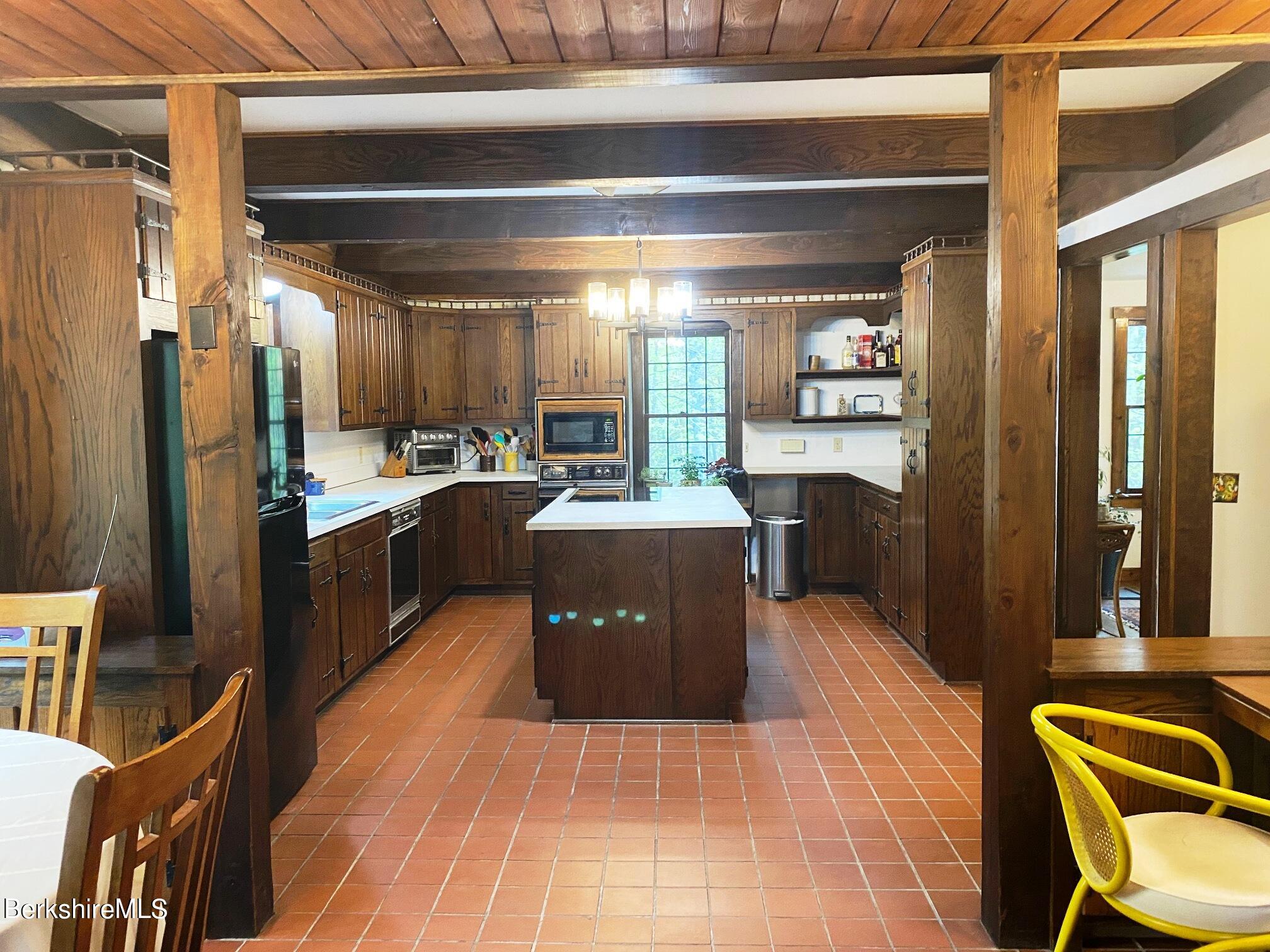 24 Andes Road Peru, MA 01235 - Photo 48 of 56 a large kitchen with stainless steel appliances kitchen island granite countertop a table chairs in it and a wooden floor