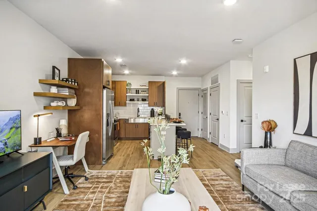 a living room with lots of furniture and kitchen view