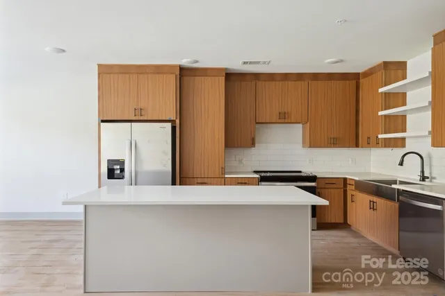 a kitchen with stainless steel appliances granite countertop a sink and a stove top oven
