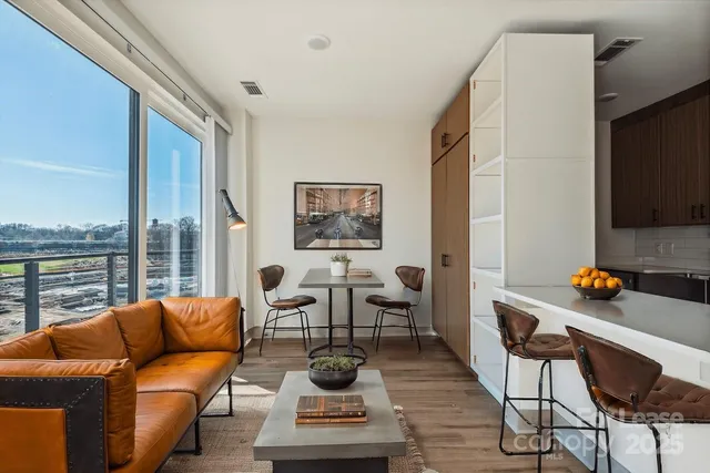 a living room with furniture a rug and a floor to ceiling window
