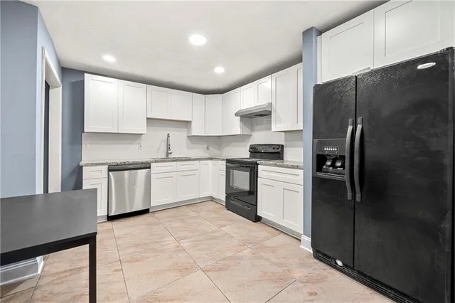 a kitchen with a refrigerator a sink and cabinets