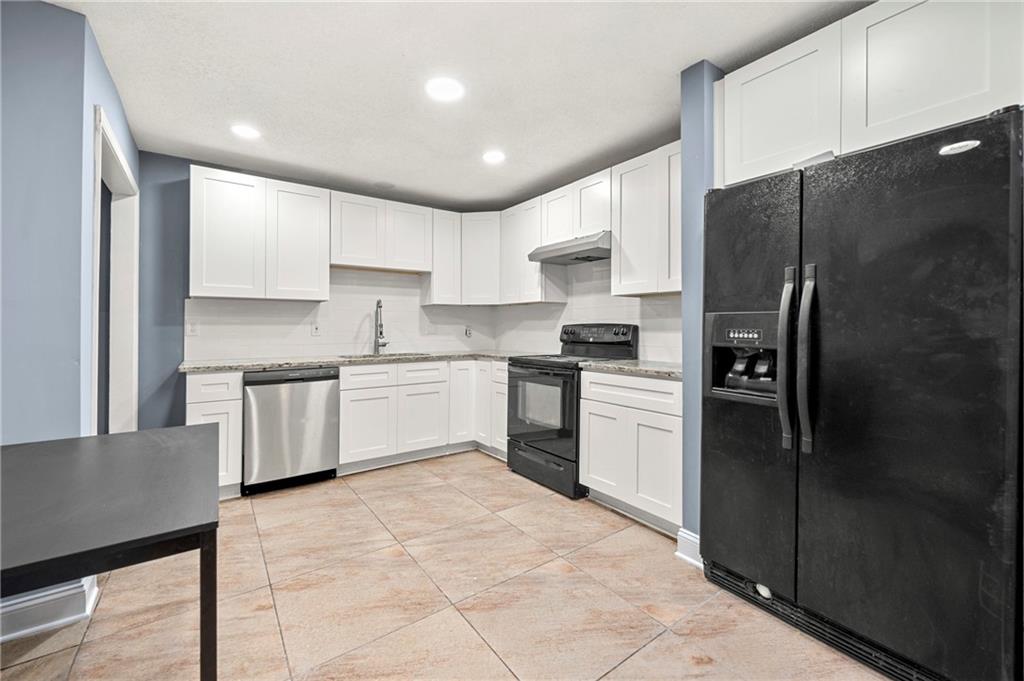 a kitchen with a refrigerator a sink and cabinets
